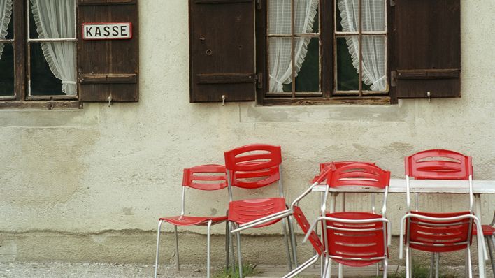 Tisch und Stühle vor einer Hauswand. (Quelle: dpa/Andrea Altemüller)