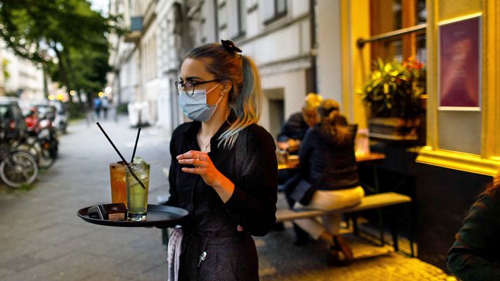 Eine Kellnerin trägt am 05.06.2020 Cocktails zu einem Tisch vor einer Cocktailbar im Berliner Stadtteil Kreuzberg. (Quelle: dpa/Carsten Koall)