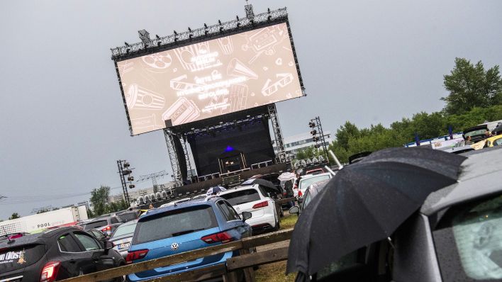 Mit Schirmen schützen sich Besucher des Autokinos auf dem Areal des Autokinos "Berlin" in Schönefeld am 13.06.2020 vor dem Regen. (Bild: dpa/Paul Zinken)