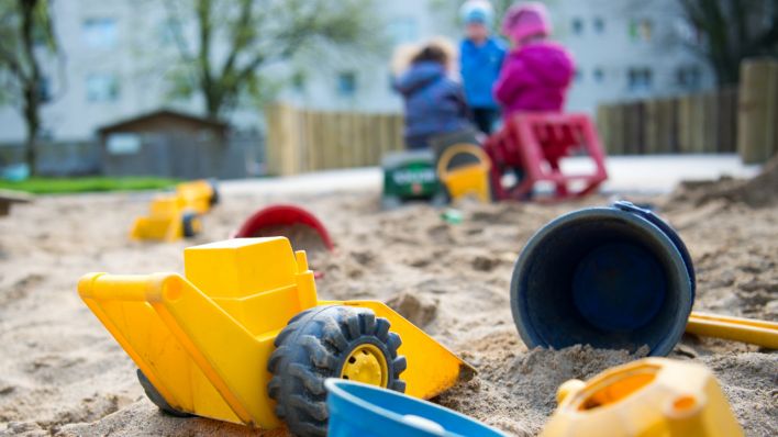 Spielzeug liegt in einem Sandkasten in einer Kindertagesstätte. (Quelle: dpa/Monika Skolimowska)