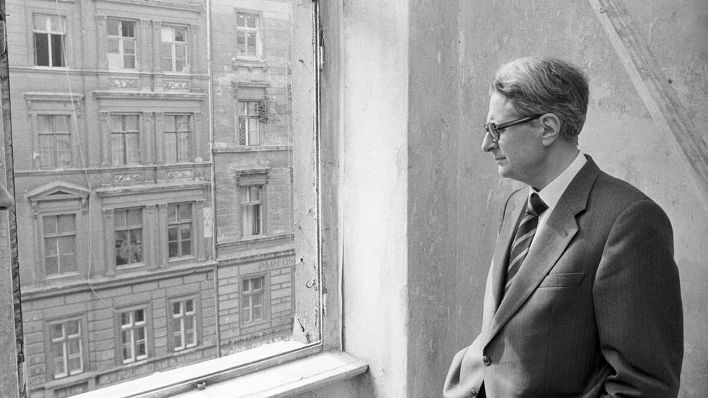 Der Regierende Bürgermeister von Berlin, Hans-Jochen Vogel (SPD) schaut am 08.04.1981 aus einem Fenster in einem Gebäude im Stadtteil Kreuzberg auf ein sanierungsbedürftiges Haus gegenüber. (Quelle: dpa/Elke Bruhn-Hoffmann)