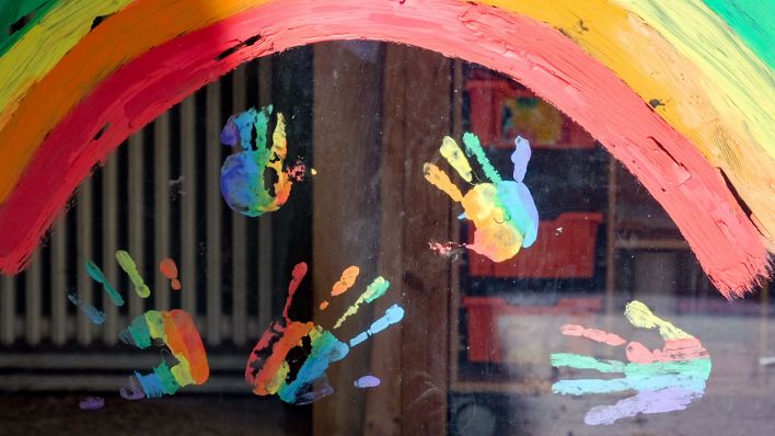 Kinderhände und ein Regenbogen sind am Fenster einer Kita zu sehen (Quelle: DPA/Jens Kalaene)