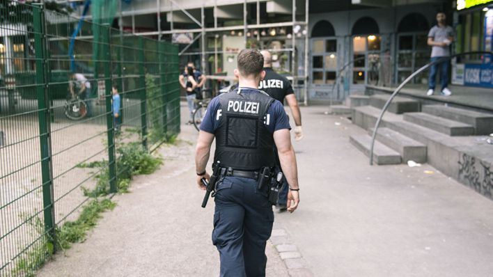 Archivbild: Eine Polizeistreife geht am 23.05.2017 in Berlin am Kottbusser Tor an Häusern und an einem Spielplatz vorbei. (Bild: dpa/Paul Zinken)