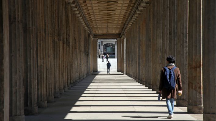 Menschen laufen auf der Museumsinsel durch den Säulengang vor der Alten Nationalgalerie (Quelle: DPA/Wolfgang Kumm)