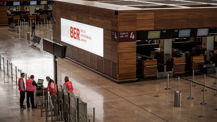 Symbolbild: Techniker und Arbeiter sind in der Abflughalle des neuen Flughafens Berlin-Brandenburg Willy-Brandt unterwegs. (Quelle: dpa/Michael Kappeler)
