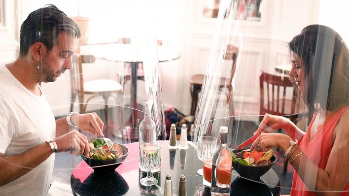 Symbolbild: 27.05.2020, Frankreich, Paris: Ein Mann und eine Frau demonstrieren in einem Pariser Restaurant das Speisen unter Plastikhauben (Quelle: dpa/Thibault Camus)
