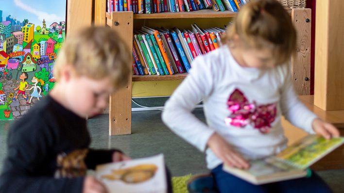 Symbolbild: 24.04.2019, Brandenburg, Wandlitz: Ein Junge und ein Mädchen schauen sich in einem Kindergarten Kinderbücher an (Quelle: dpa/Skolimowska)