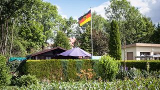 ARCHIV - Eine Deutschlandfahne mit dem Bundesadler weht in einem Kleingarten (Quelle: dpa/Endig)