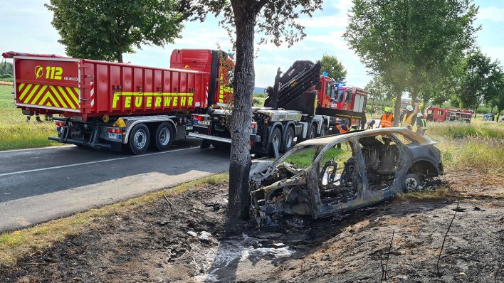 Das ausgebrannte Unfallwrack eines Autos steht am 28.07.2020 an einem Baum in Groß Kreutz bei Potsdam (Quelle: dpa/Julian Stähle)