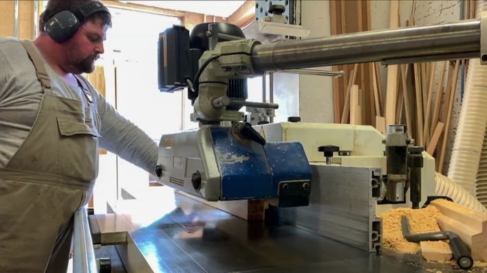Ein Handerwerker arbeitet in einem Brandenburger Betrieb an einer Maschine (Bild: rbb)