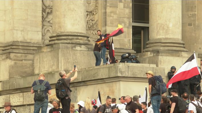 Demonstranten stehen auf den Reichstagstreppen.