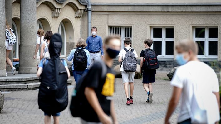 Schüler betreten am 10.08.2020 mit Mundschutz den Eingang zum Rheingau Gymnasium in Berlin. (Bild: dpa/Kay Nietfeld)
