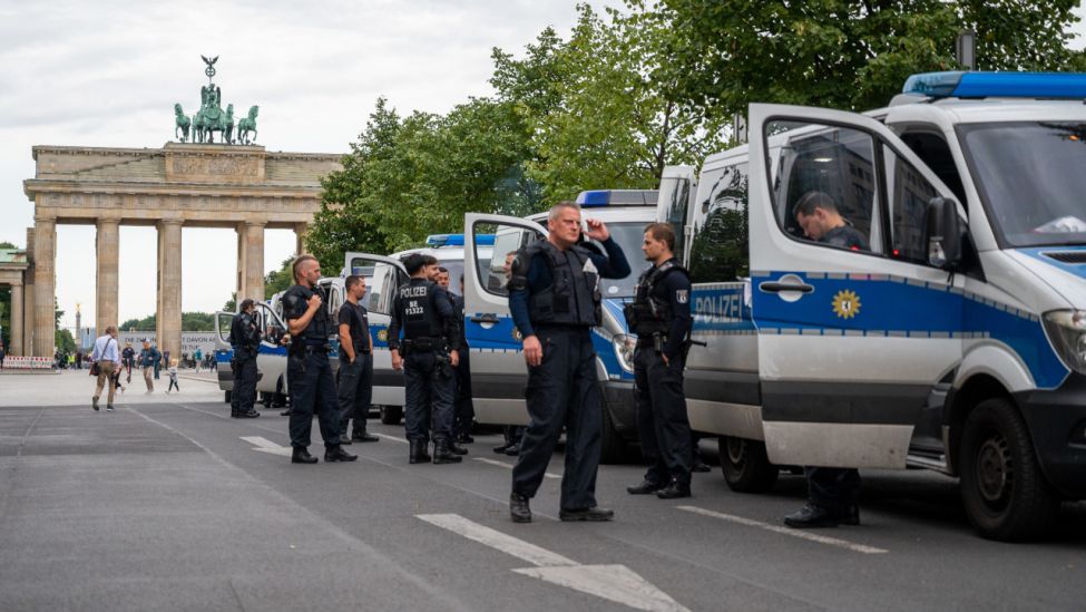 Polizisten stehen am frühen Morgen neben Polizeifahrzeugen vor dem Brandenburger Tor in Vorbereitung auf die heutigen Proteste gegen die staatlichen Corona-Maßnahmen. (Quelle: dpa/Christophe Gateau)
