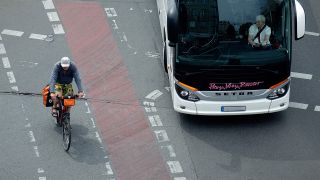 Ein Radfahrer hat vor dem rechtsabbiegenden Bus die Vorfahrt (Bild: dpa/Sascha Steinach)