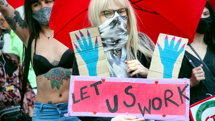 Teilnehmerinnen einer Protestaktion für die Öffnung von Prostitutionsstätten stehen nahe des Bundesrates und halten Schilder mit der Aufschrift «Let us work» (Lasst uns arbeiten) (Bild: dpa/Wolfgang Kumm)