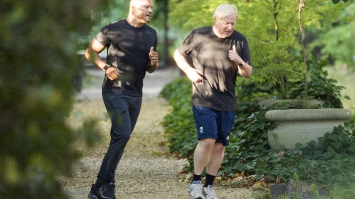 Der britische Premier Minister Boris Johnson beim Lauftraining mit seinem persönlichen Star-Trainer Harry Jameson (l.). (Quelle: dpa/B. Page)