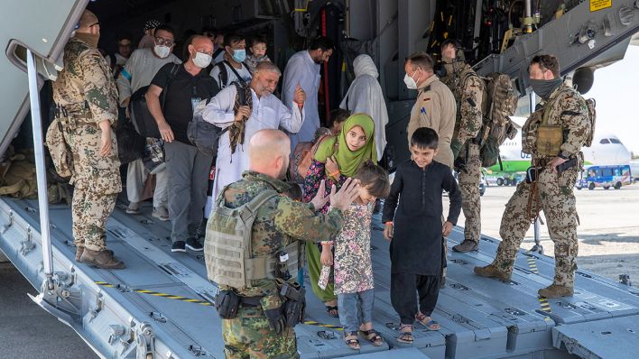 Aus Afghanistan evakuierte Menschen verlassen ein Transportflugzeug der Bundeswehr (Quelle: dpa/Tessensohn)