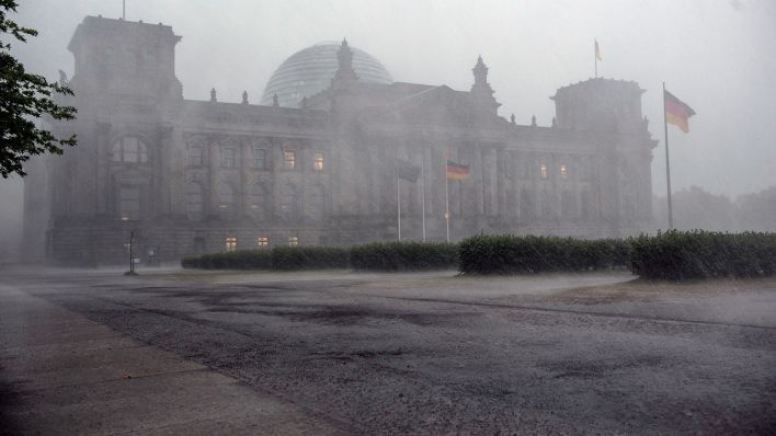 Starker Regenschauer verhindert in Berlin die Sicht auf den Reichstag. (Quelle: dpa/Paul Zinken)