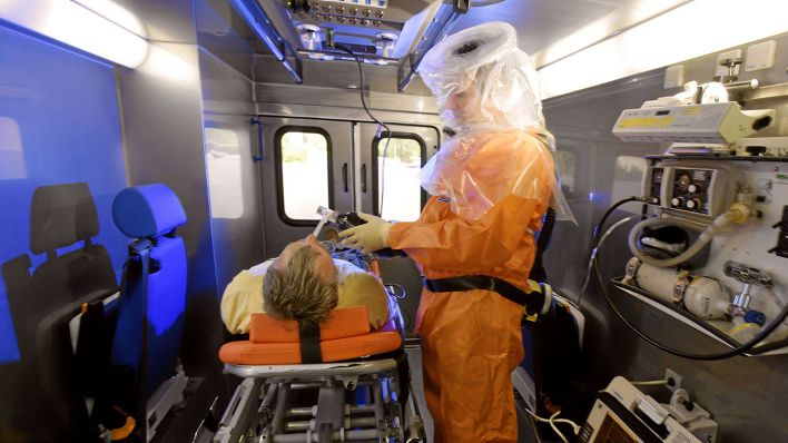 Ein Rettungssanitäter behandelt einen Mann im Infektionsrettungswagen der Rettungswache Königs Wusterhausen