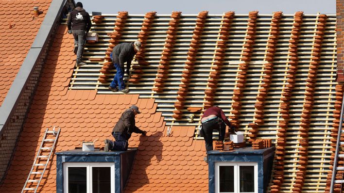 Symbolbild: Dachdecker decken Haus mit neuen Ziegeln (Quelle: imago images/imagebroker)