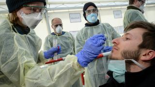 Mitarbeiter des Tropeninstituts München nehmen einen Corona-Abstrich aus der Nase eines Testpatienten (Bild: imago images/Stefan M. Prager)
