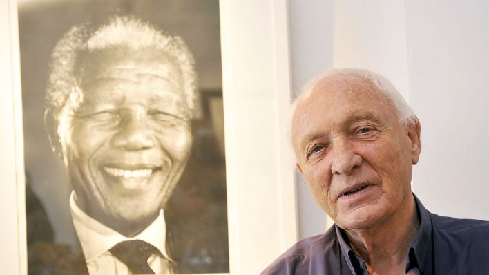 Archiv - Der Fotograf Jürgen Schadenberg ist vor seinem Porträt von Nelson Mandela zu sehen. (Bild: dpa/UPPA/Photoshot)