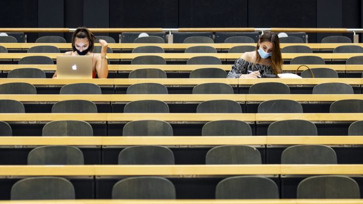 Studentinnen mit Mund-Nasen-Schutz sitzen in einem Hörsaal einer Universität (Quelle: dpa/Alexandra Wey)