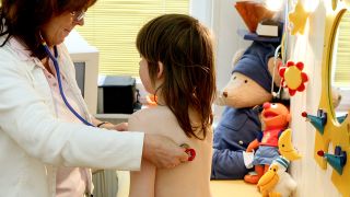 Symbolbild: Eine Ärztin untersucht ein Mädchen mit einem Stethoskop (Bild: dpa/Patrick Pleul)