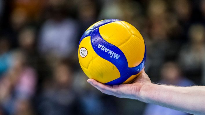 Ein Spieler hält einen Volleyball. Quelle: imago images/Gerold Rebsch