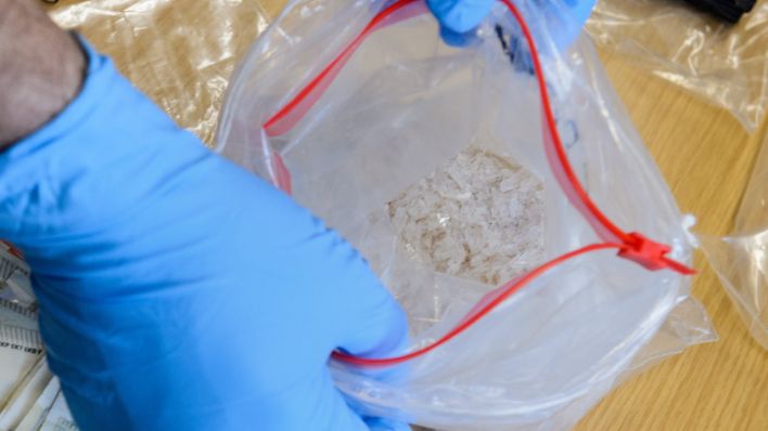 Ein Kriminalbeamter präsentiert während einer Pressekonferenz unter anderem bei Durchsuchungen sichergestelltes sogenanntes "Crystal Meth" in einer Plastiktüte.