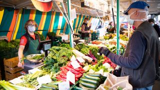 Gemüsehändler und ihre Kunden auf dem Isemarkt in Hamburg tragen am 28.04.2020 Mund-Nasen-Schutz. (Quelle: dpa/Christian Charisius)