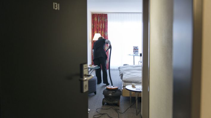 Ein Zimmermaedchen beim Staubsaugen in einem Hotel (Quelle: dpa/Christian Beutler)