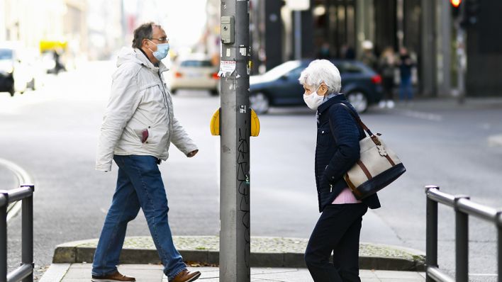 Passanten auf Berliner Straßen mit Maske (Quelle: dpa/Abdulhamid Hosbas)