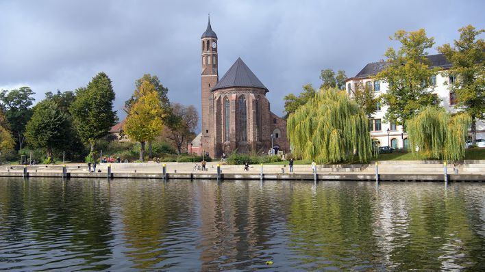 Symbolbild: Die Johanniskirche und die an der Promenade Am Salzhof stehenden Bäume spiegeln sich im Wasser der Brandenburger Niederhavel, in Brandenburg an der Havel. (Quelle: dpa/S. Stache)