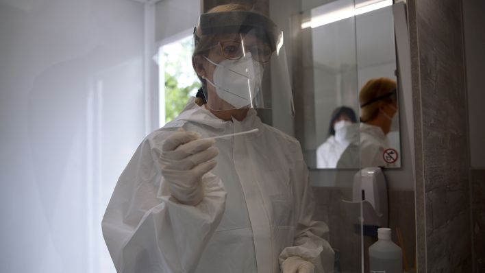 Symbolbild: Petra von Saurma, Teamleiterin des Pandemieteams des Gesundheitsamtes Mitte, hält im neuen Corona-Testmobil des Bezirks einen Tupfer vor einem Übungstest in der Hand. (Quelle: dpa/Sven Braun)