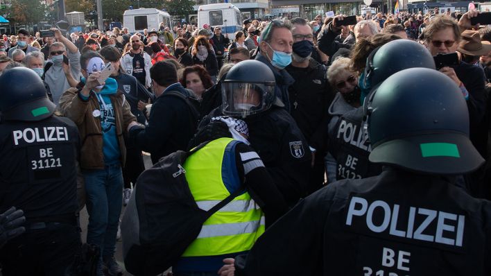 Berlin: Ein Polizist hindert einen Teilnehmer der Demonstration gegen die Corona-Auflagen auf dem Alexanderplatz am Weitergehen. Quelle: Paul Zinken/dpa