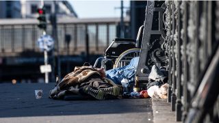 Obdachlose liegen auf einer Brücke unweit des Bahnhof Friedrichstraße. Quelle: Paul Zinken/dpa