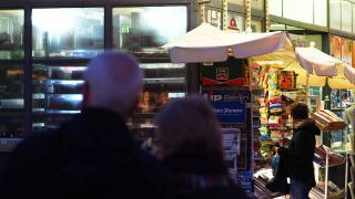 Eine Frau steht am 03.02.2016 nach Einbruch der Dunkelheit an einem Kiosk in Berlin im Stadtteil Friedenau (Quelle: dpa/Wolfram Steinberg)