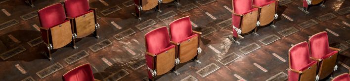 Ein Mitarbeiter trägt Stühle aus den Sitzreihen des Zuschauerraums des Berliner Ensembles. (Quelle: dpa/Britta Pedersen)