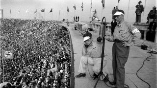 Sportreporter stehen während der Olympischen Spiele in Berlin 1936 im Olympiastadion. (Bild: dpa/United Archives)