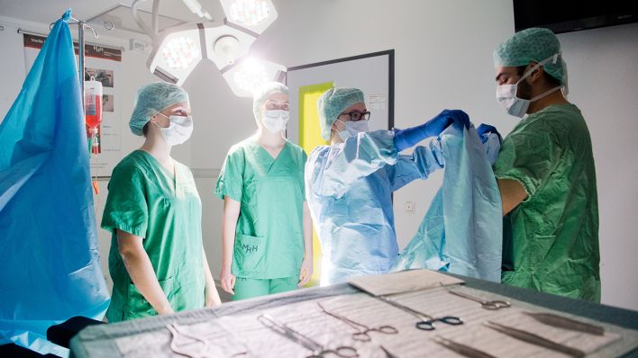 Medizinstudenten üben in einem nachgebildeten OP-Raum das hygienisch korrekte Anlegen eines OP-Kittels (gestellte Szene) am 05.02.2019 in Hannover. (Quelle: dpa/Julian Stratenschulte)
