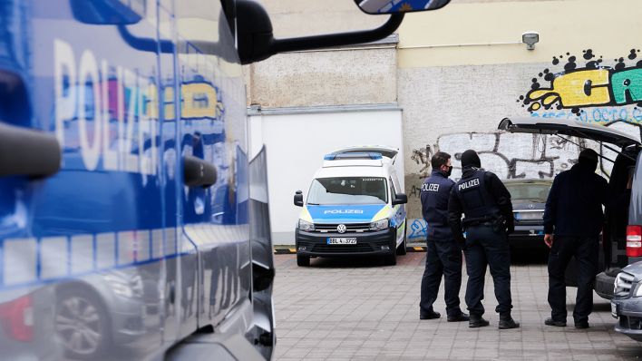 Ein Polizist steht am 18.11.2020 bei einem Einsatz auf einem Parkplatz. Die Berliner Polizei hat Räume eines islamischen Kulturvereins in Neukölln und eine Wohnung durchsucht. (Quelle: dpa/Annette Riedl)