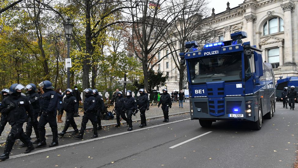 Wasserwerfer der Polizei fahren am 18.11.2020 bei einer Demonstration gegen die Corona-Einschränkungen der Bundesregierung zwischen dem Brandenburger Tor und dem Reichstagsgebäude auf.