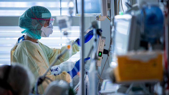 Symbolbild - Eine Pflegerin betreut in einer Intensivstation einen Covid-Patienten. (Bild: dpa/Jens Büttner)