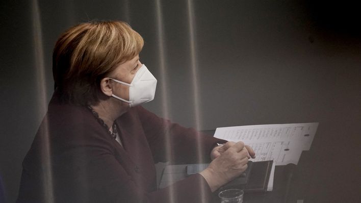 Bundeskanzlerin Angela Merkel (CDU) verfolgt am 26.11.2020 im Bundestag die Debatte nach der Abgabe der Regierungserklärung zur Bewältigung der Corona-Pandemie und trägt dabei ihre Maske. (Quelle: dpa/Michael Kappeler)