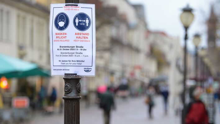 Potsdam: Ein Plakat mit dem Aufdruck "Maskenpflicht" und "Abstand halten" hängt an einem Laternenmast in der Brandenburger Straße (Quelle: dpa/Soeren Stache)