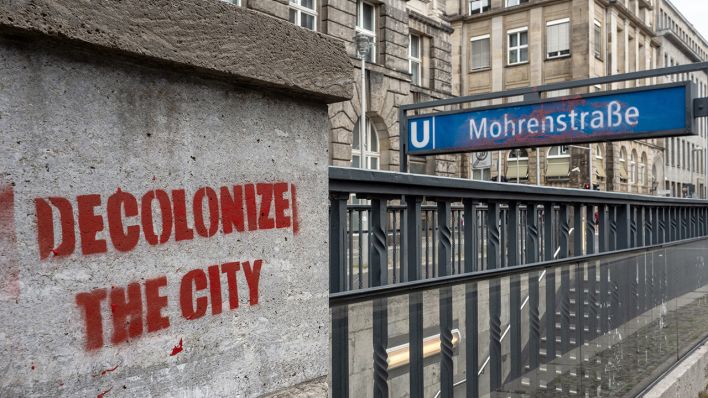 Blick auf die U-Bahn-Station Mohrenstraße an der ein Graffiti "decolonize the city" aufgesprüht wurde (Quelle: DPA/Paul Zinken)
