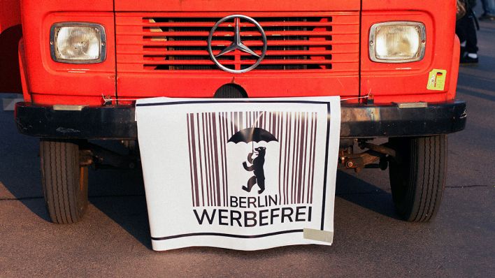 14.04.2018, Berlin: An einem alten Mercedes hängt ein Plakat einer Initiative für den Volksentscheid "Berlin werbefrei" (Quelle: dpa/Wolfram Steinberg)