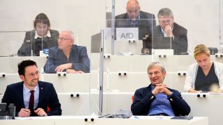 Hans-Christoph Berndt (vorne, rechts), AfD-Fraktionsvorsitzender, und Dennis Hohloch (l), Parlamentarischer Geschäftsführer der AfD-Fraktion, lachen während einer Sondersitzung des Landtages zu den neuen Corona-Verordnungen und Regeln. (Quelle: dpa/Soeren Stache)