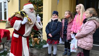 Kinder aus der Grundschule begrüßen den Weihnachtsmann in Himmelpfort. (Quelle: dpa/Bernd Settnik)
